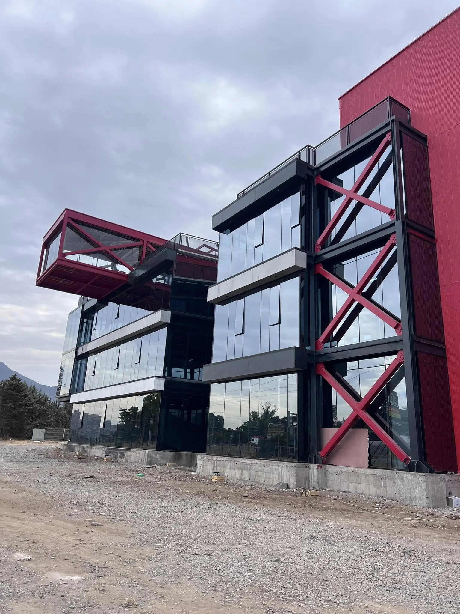 Edificio corporativo con piel de vidrio y estructura roja